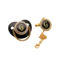 Close-up of black and gold baby pacifier with rhinestone-encrusted letter G and matching clip - Letter G