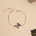 Macro detail of a butterfly pendant with iridescent wings and tiny crystals on a gold chain - 10# Bracelet Colorful