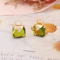 Detailed macro view of gold-plated handbag earrings with green zircon and crescent moons - Grass Green