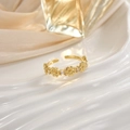 Elegante anillo abierto dorado con motivos florales de circón sobre fondo de mármol pulido - Diseño Detalle Flor (JZ0108)