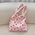 Detailed view of pink tote bag with cat prints and embossed crinkle texture on sofa - Black Cat Pear