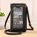 Black touchscreen crossbody phone bag with gold hardware and a clear display window - Black
