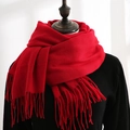 Deep red cashmere-like winter scarf with long tassels draped on a mannequin - Red