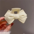 Elegante pinza per capelli a fiocco beige crema con finitura opaca tenuta in mano - Bianco Sporco