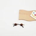 Close-up of retro mini round sunglasses with brown lenses and gold frames on white backdrop - Brown