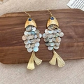 Detalle macro de pendientes en forma de pez con escamas de nácar y acabado en metal dorado - Gancho Dorado - Escamas de Pez Blancas Irisadas