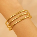 Three-piece set of golden bamboo-joint stainless steel bangles worn on a wrist - Realistic Bamboo 3-Piece Set (1942)