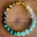 Multicolor natural semi-precious gemstone beaded bracelet on a rustic wood background - Tiger Eye Citrine Money Attract