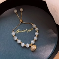 Detalle de pulsera de ojo de gato con colgante de concha dorada en bandeja - Dorado (Colgante de Concha de Ojo de Gato)