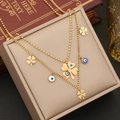 Close-up of double-layer gold necklace featuring clover and evil eye charms on a jewelry box - 1# Necklace
