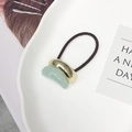 Elastic hair tie with gold metal clasp and green crescent charm on a white tray - Gold/Mint Green