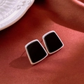 Detalle de pendientes geométricos plateados con insertos negros sobre fondo seda - Pin de Acero - Pendientes de Botón de Trapecio de Resina Negra