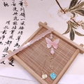 Dettaglio del fermaglio a farfalla in resina rosa con nappe e foglia di ginkgo dorata - Farfalla Rosa