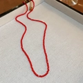 Dettaglio della collana di perle di vetro sfaccettate rosse con chiusura dorata - Rosso