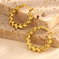 Detailansicht goldener Lorbeerblatt-Ohrringe auf texturierter Steinoberfläche - Stil 1-Lorbeerblatt-Reifen