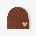Deep brown knitted beanie with beige fuzzy heart patch for warm winter outdoor style - One Size / Rust red