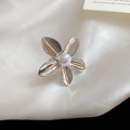 Dettaglio macro di un anello a fiore argentato con perla centrale su seta bianca - Fiore di Perla Argento