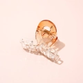Close-up of translucent gradient amber acetate hair claw clip with golden metal spring - Cross Orange