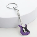Detail shot of purple and black enamel guitar keychain on a white pedestal display - Purple