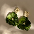 Macro-opname van donkergroene acryl bloemoorbellen met goudkleurige metalen accenten - Groen
