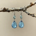 Elegant teardrop blue moonstone earrings with silver frame hanging on a natural branch - Blue
