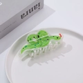 Détail de la pince à cheveux en acrylique vert en forme de serpent sur plateau blanc - Serpent Vert