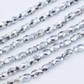 Macro shot of silver faceted fish-shaped beads arranged in neat diagonal rows - 6*10mm (approximately 50 Beads) / Silver