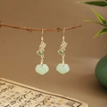 Detail of green fan-shaped tassel earrings with gold hooks on a traditional background - Cloud Faux Jade (E6455)