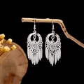 Detailed view of silver ethnic leaf earrings with tassels hanging on a wooden branch - Silver Heart Hollow Multi-Row Tassel Style (E2873-29)