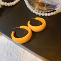Detailed view of glossy orange C-shape earrings with silver needles and pearl decor - Orange-Yellow C-Shaped Resin Hoop Earrings