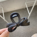 Close-up of matte black butterfly hair claw clip with elegant hollow-out design held in hand - Approx. 8cm / Matte Black