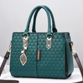 Dark green patchwork tote bag with quilted triangle texture and golden leaf pendant - Green