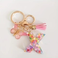 Pink glitter resin letter X keychain with butterfly charm and pink tassel in gold finish - Letter X