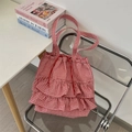 Detail of red gingham ruffle tote bag with drawstring on a modern transparent chair - Red Checkerboard