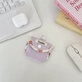 Close-up of purple fabric headphone case with floral trim and plastic carabiner clip - Grid Purple