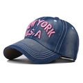 Dettaglio del ricamo rosa New York sul cappellino da baseball in denim blu scuro lavato - Rosa