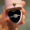 Close-up of pink gem ring with halo setting in a heart-shaped velvet gift box - Square Pink Zirconia