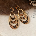 Detail shot of multi-layer gold earrings with leopard print leather on soft fur background - Triple Layer Style (Gold/Leopard)