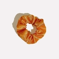 Detail of a bright orange satin scrunchie showing glossy texture and elegant folds - Satin 12 (Bright Orange)