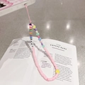 Macro detail of dopamine-style colorful heart beads and LOVE lettering phone wrist strap - Rainbow Pink Rope