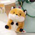 Cute plush fox keychain with orange and white fur on a green canvas bag - Fox