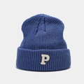 Macro shot of dark blue knitted beanie featuring a white embroidered letter P on cuff - Fog Blue