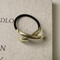 Minimalistische zwarte elastische haarelastiek met een gepolijst goudkleurig metalen accent - Gekruist / Goud