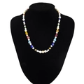 Handmade necklace with white pearls and vibrant colorful glass beads on a black bust display - Multicolor