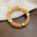 Detailed shot of amber acrylic resin bangle with gold metallic beads on fabric - Yellow (Amber Pattern)