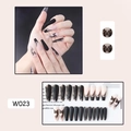 Detail of long ballerina nails with black butterfly design and nude patchwork texture - W023 Black Butterfly