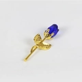 Élégante broche rose en métal doré avec un cristal bleu facetté sur fond blanc pur - Tige Dorée Fleur Bleue Non Emballée
