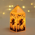 Detail van oranje oplichtende Halloween lantaarn met zwarte heks- en vleermuisfiguren - Heks