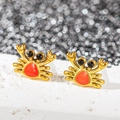 Gros plan de boucles d'oreilles crabe dorées en émail orange et petites gemmes noires - Crabe