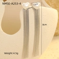 Macro detail of silver tassel earrings with heart accent on a textured display - Silver Heart Tassel